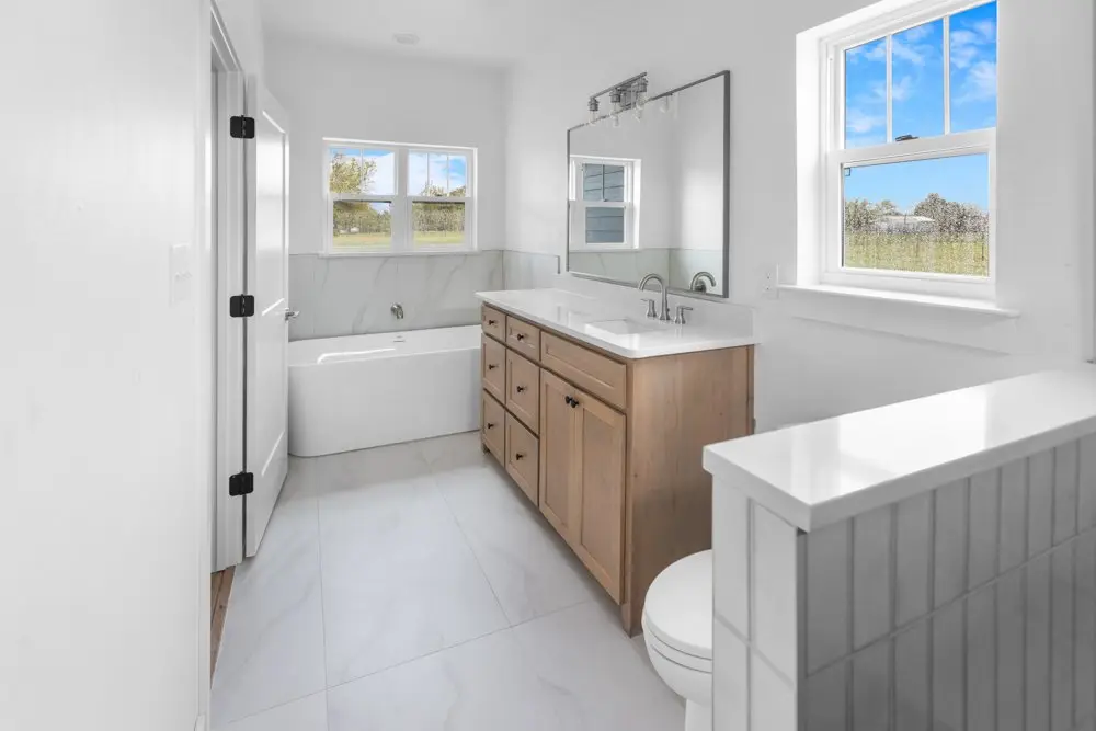 Bathroom with a tub, vanity and windows, The Dahl House, a custom home in Sherman, Texas