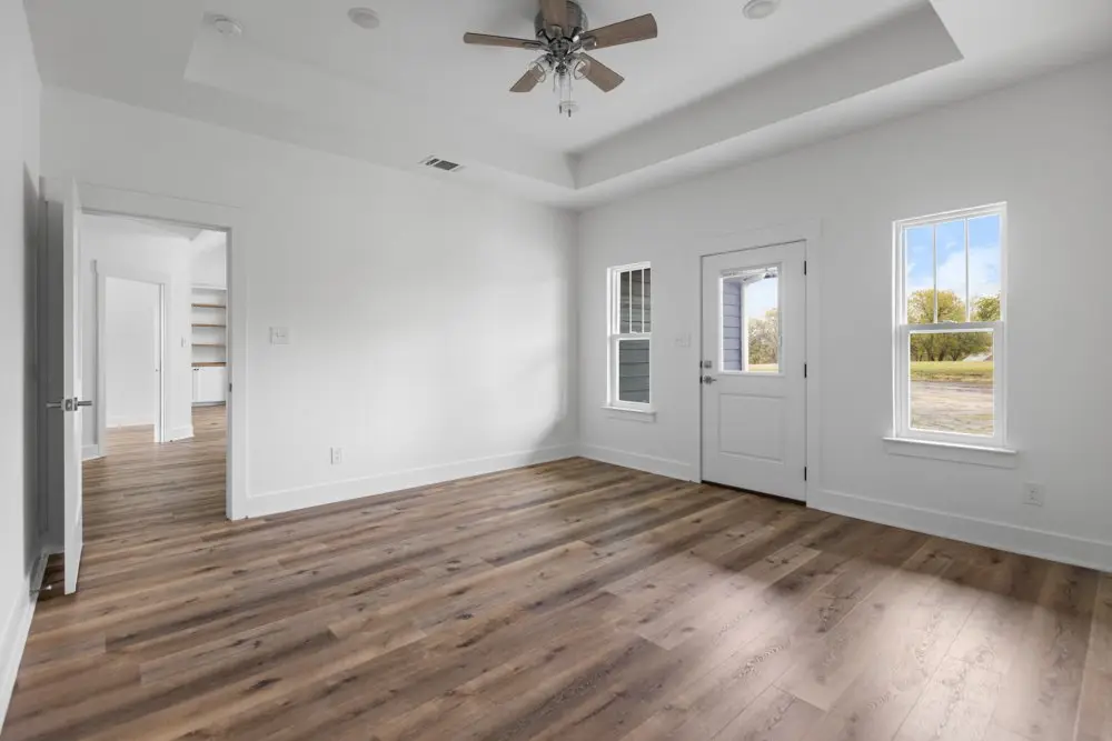 Bedroom with a tray ceiling and door to outside, The Dahl House, a custom home in Sherman, Texas