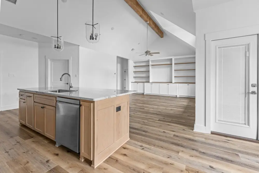 Kitchen island with the living room built-ins beyond, The Dahl House, a custom home in Sherman, Texas