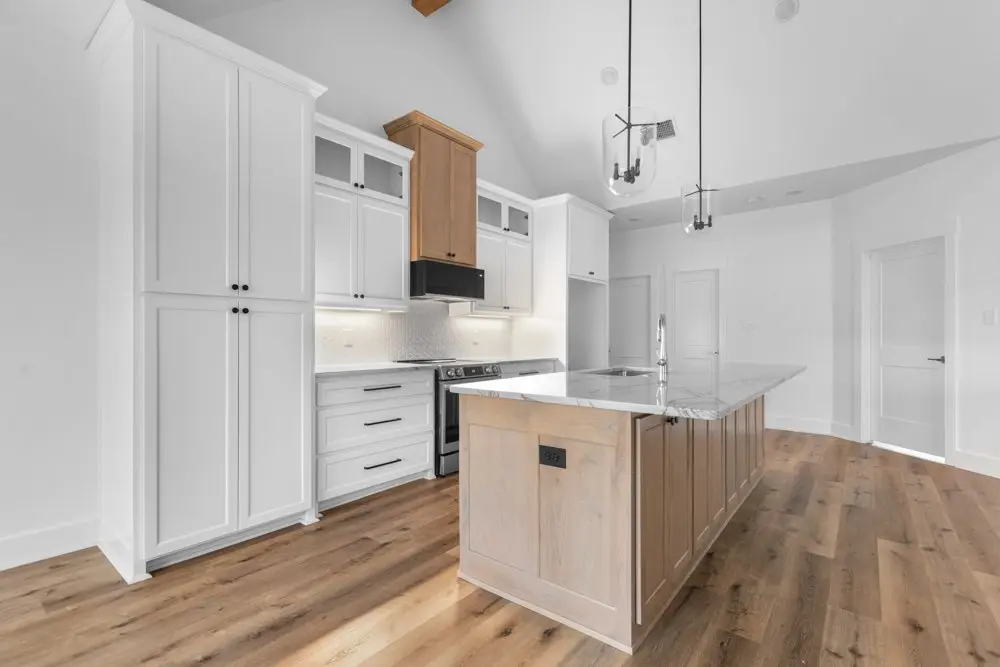 Kitchen island beneath the wood vent hood, The Dahl House, a custom home in Sherman, Texas