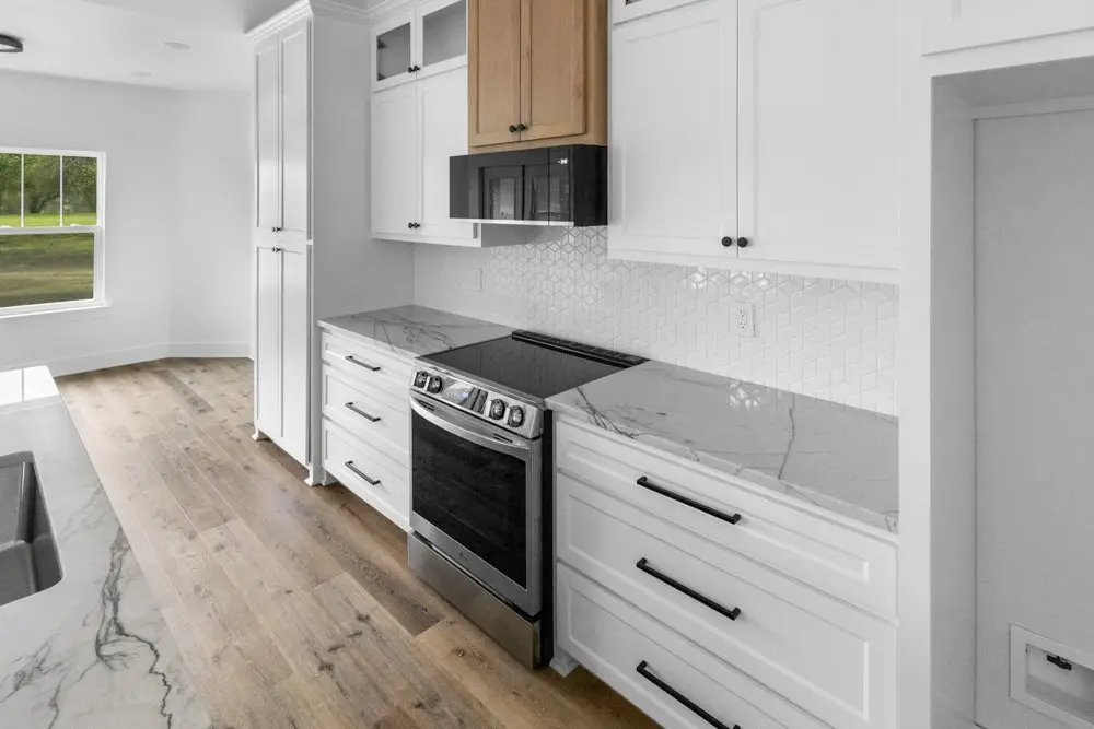 Kitchen range set into white cabinetry, The Dahl House, a custom home in Sherman, Texas