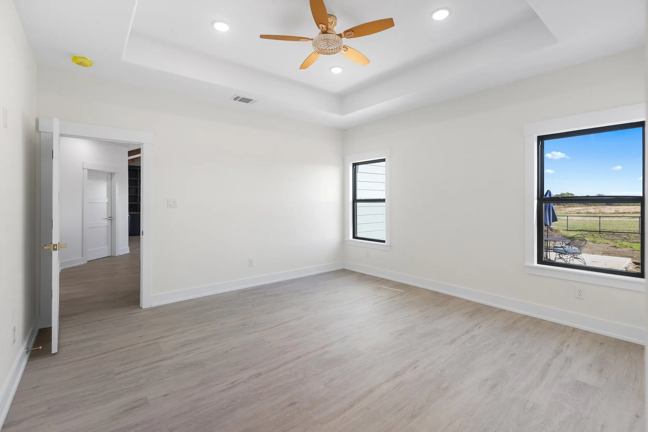 Bedroom with a tray ceiling and corner window, The Lugo House, a custom home in Sherman, Texas