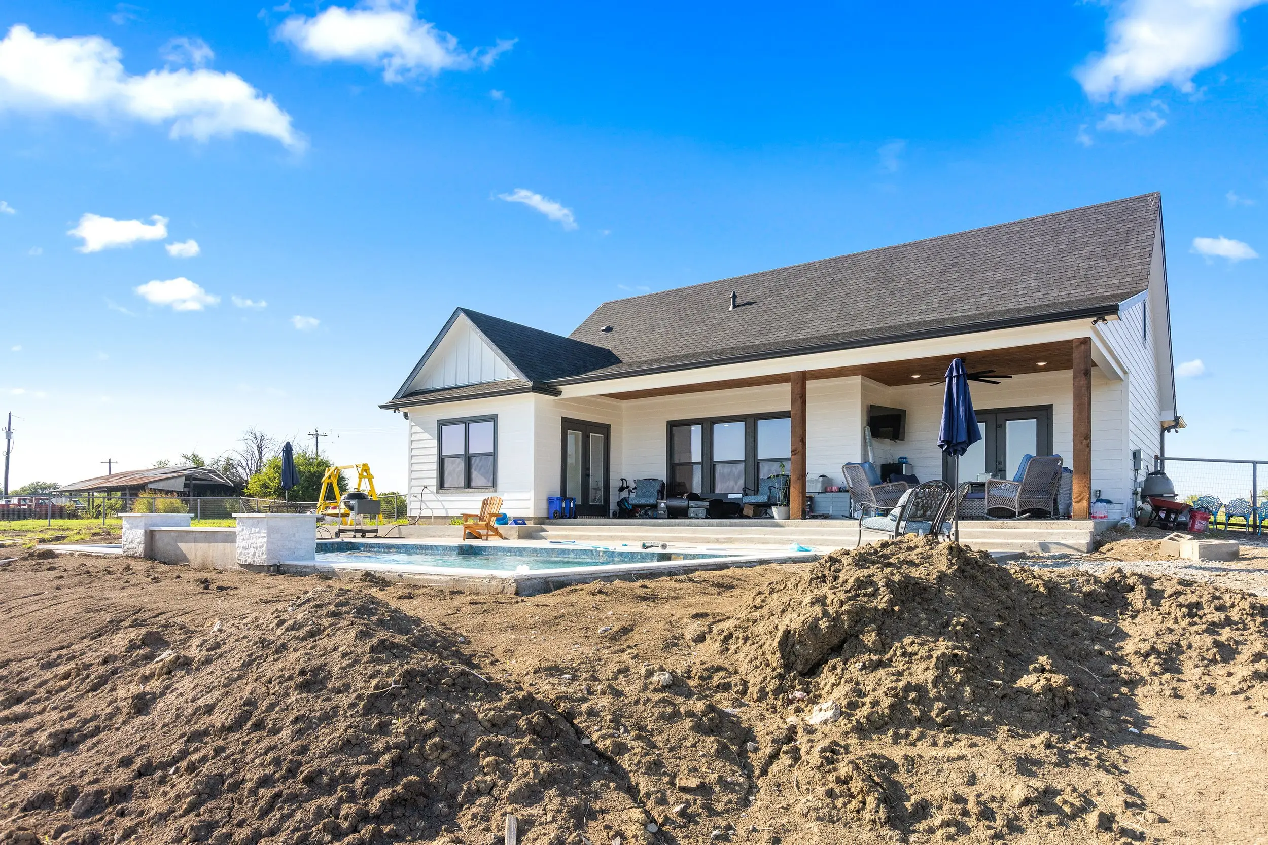 Rear of the house with the pool and covered patio, The Lugo House, a custom home in Sherman, Texas
