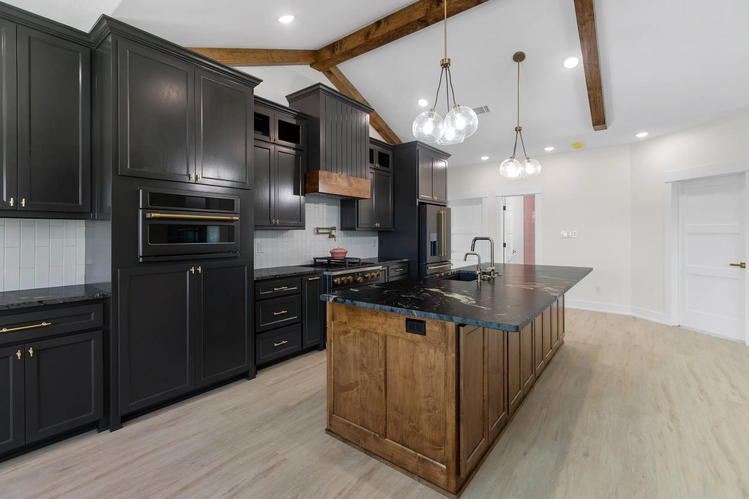Kitchen island under exposed beams, The Lugo House, a custom home in Sherman, Texas
