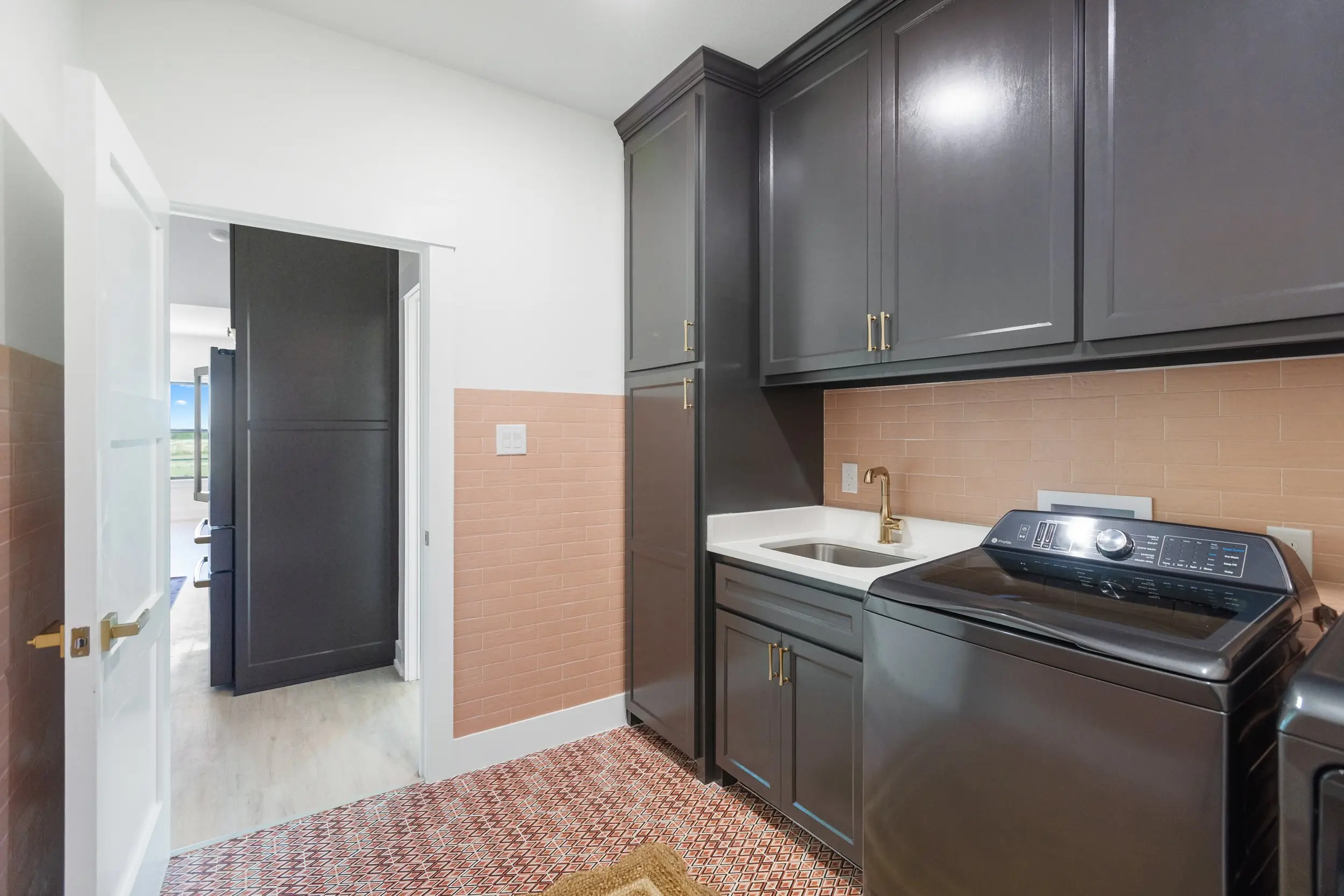 Laundry room with dark cabinetry, The Lugo House, a custom home in Sherman, Texas
