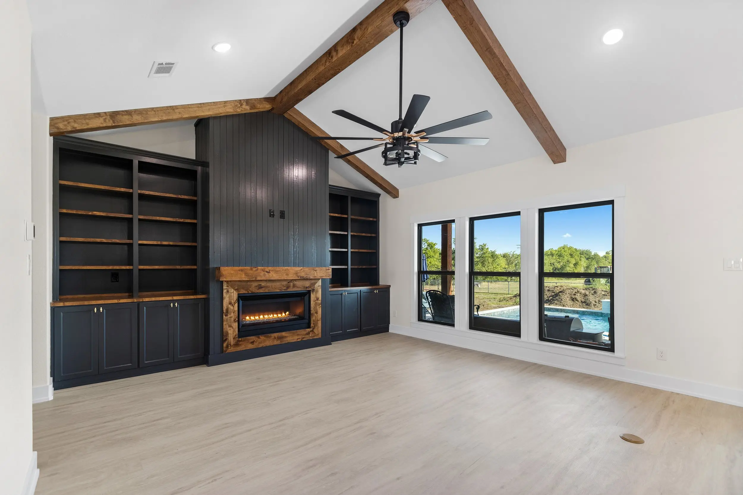 Living room with built-in shelving beside the fireplace, The Lugo House, a custom home in Sherman, Texas