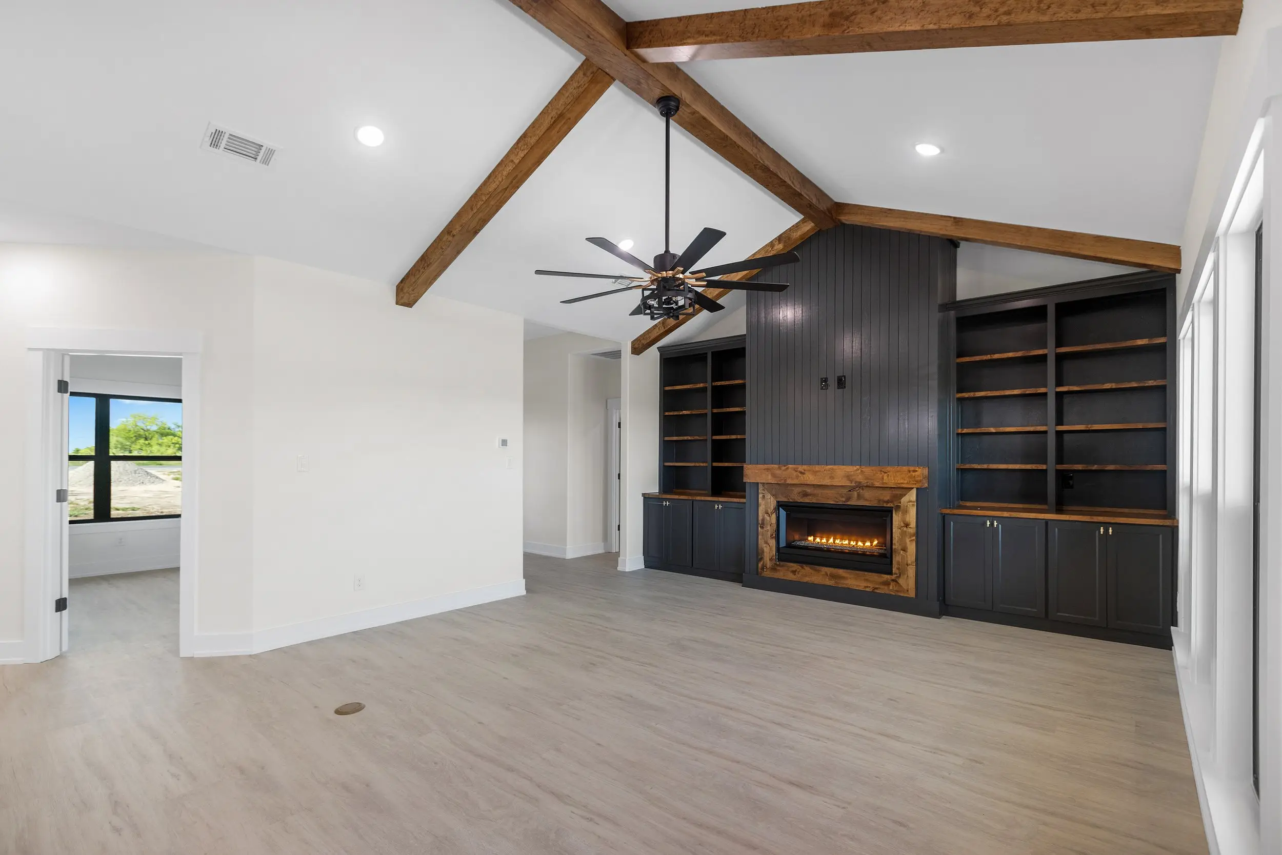 Living room with exposed beams and a fireplace, The Lugo House, a custom home in Sherman, Texas