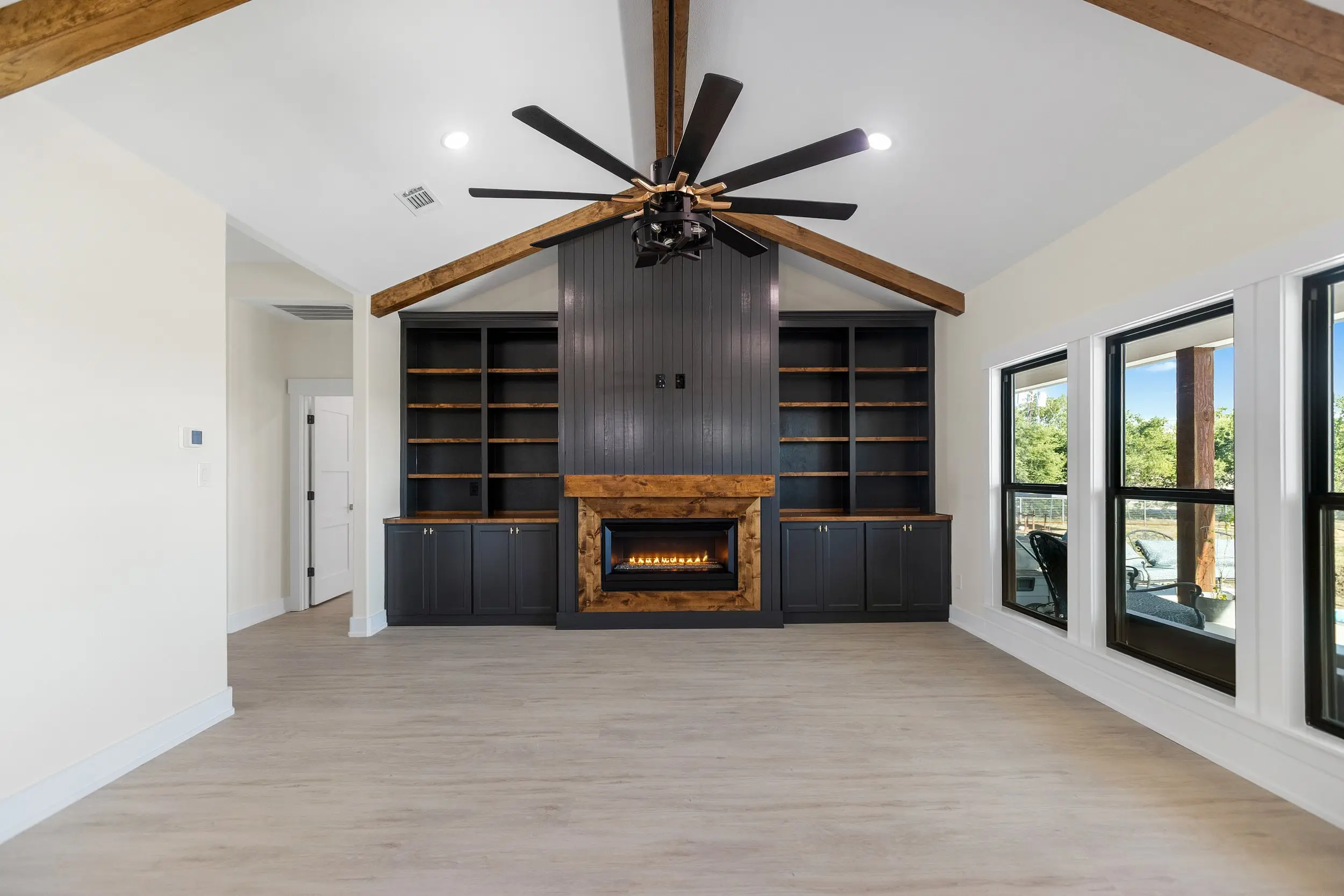 Living room with a fireplace, built-ins and beams, The Lugo House, a custom home in Sherman, Texas