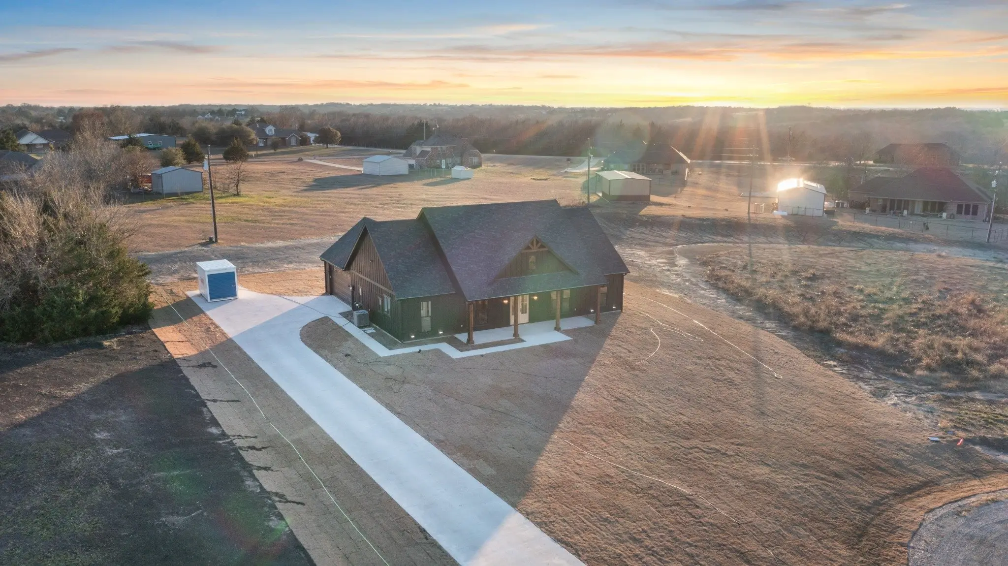 Aerial view of the house on its acreage at sunset, The Wester House, a custom home in Sherman, Texas