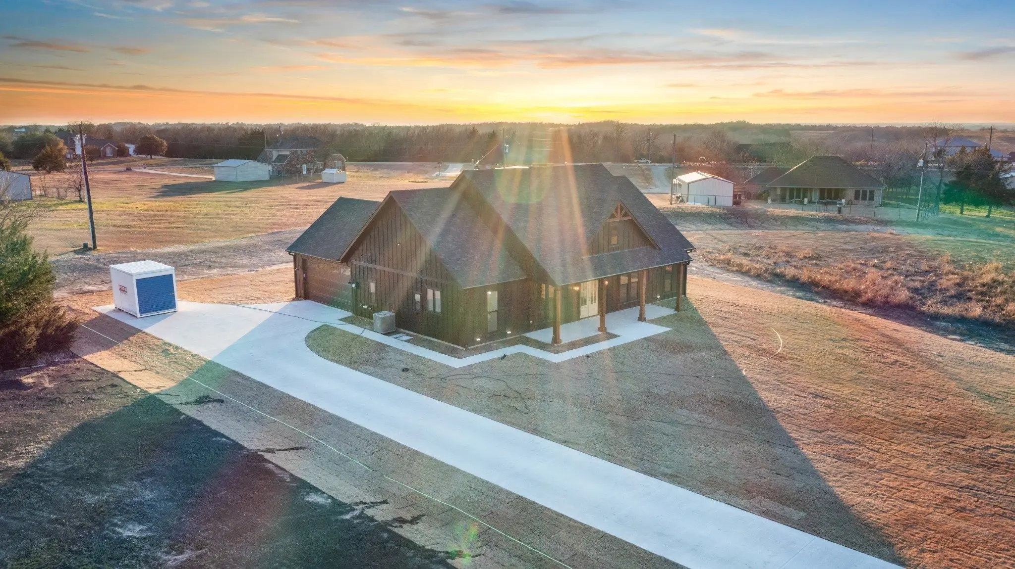 Aerial view of the front elevation at sunset, The Wester House, a custom home in Sherman, Texas