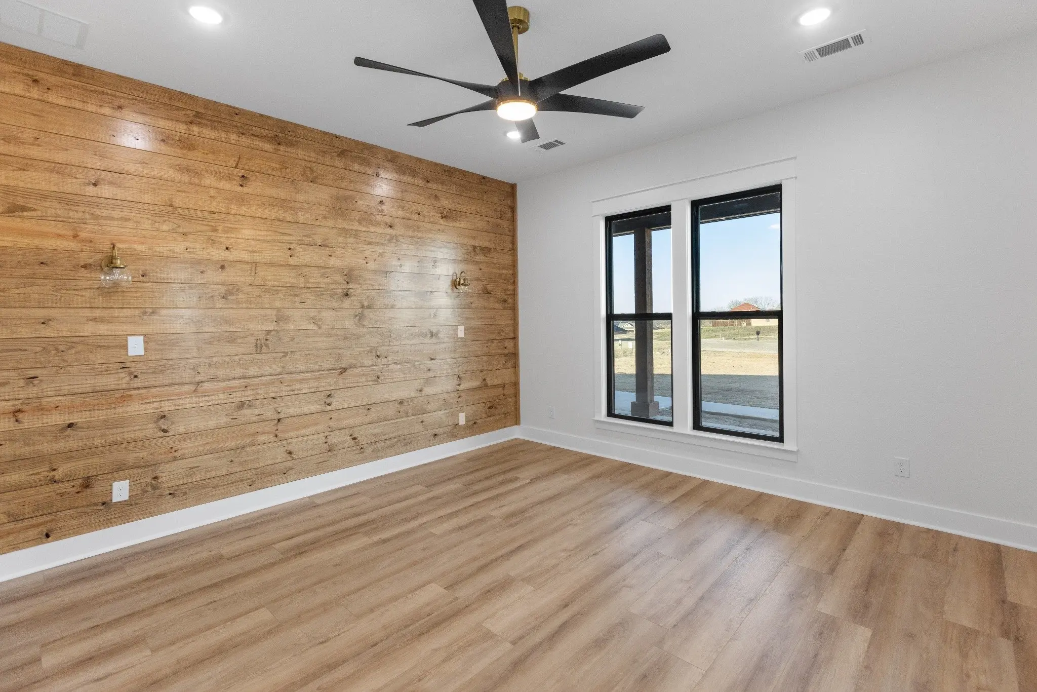 Bedroom with a cedar plank accent wall, The Wester House, a custom home in Sherman, Texas