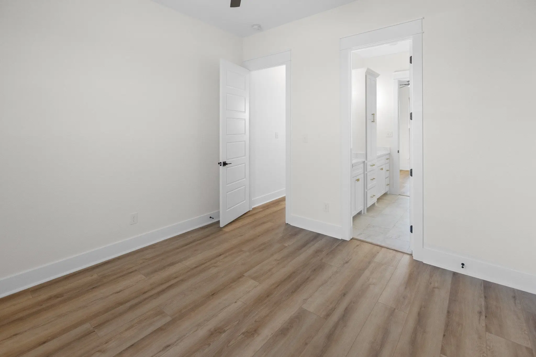Bedroom with its ensuite door open, The Wester House, a custom home in Sherman, Texas