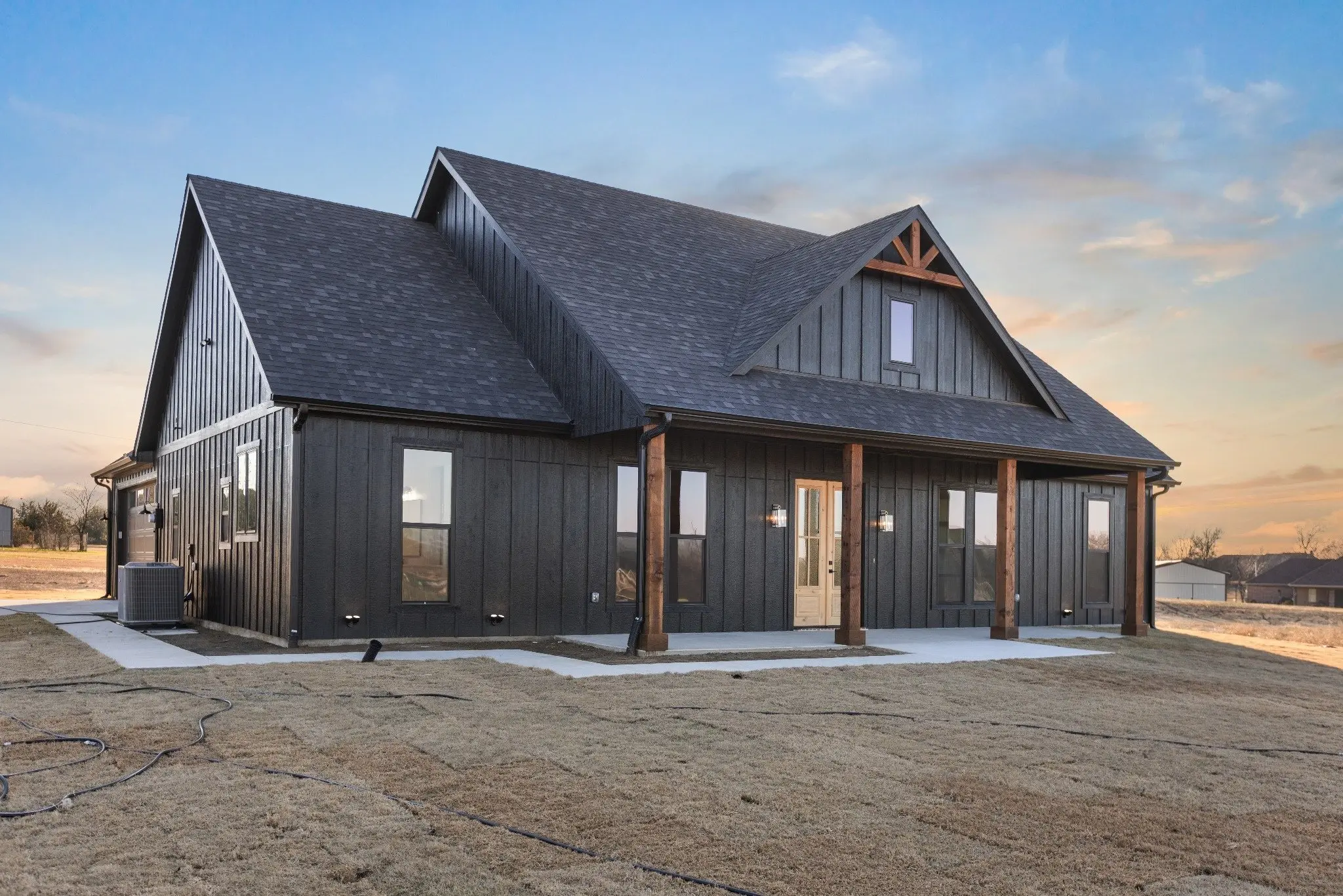 Side elevation in dark board and batten at dusk, The Wester House, a custom home in Sherman, Texas