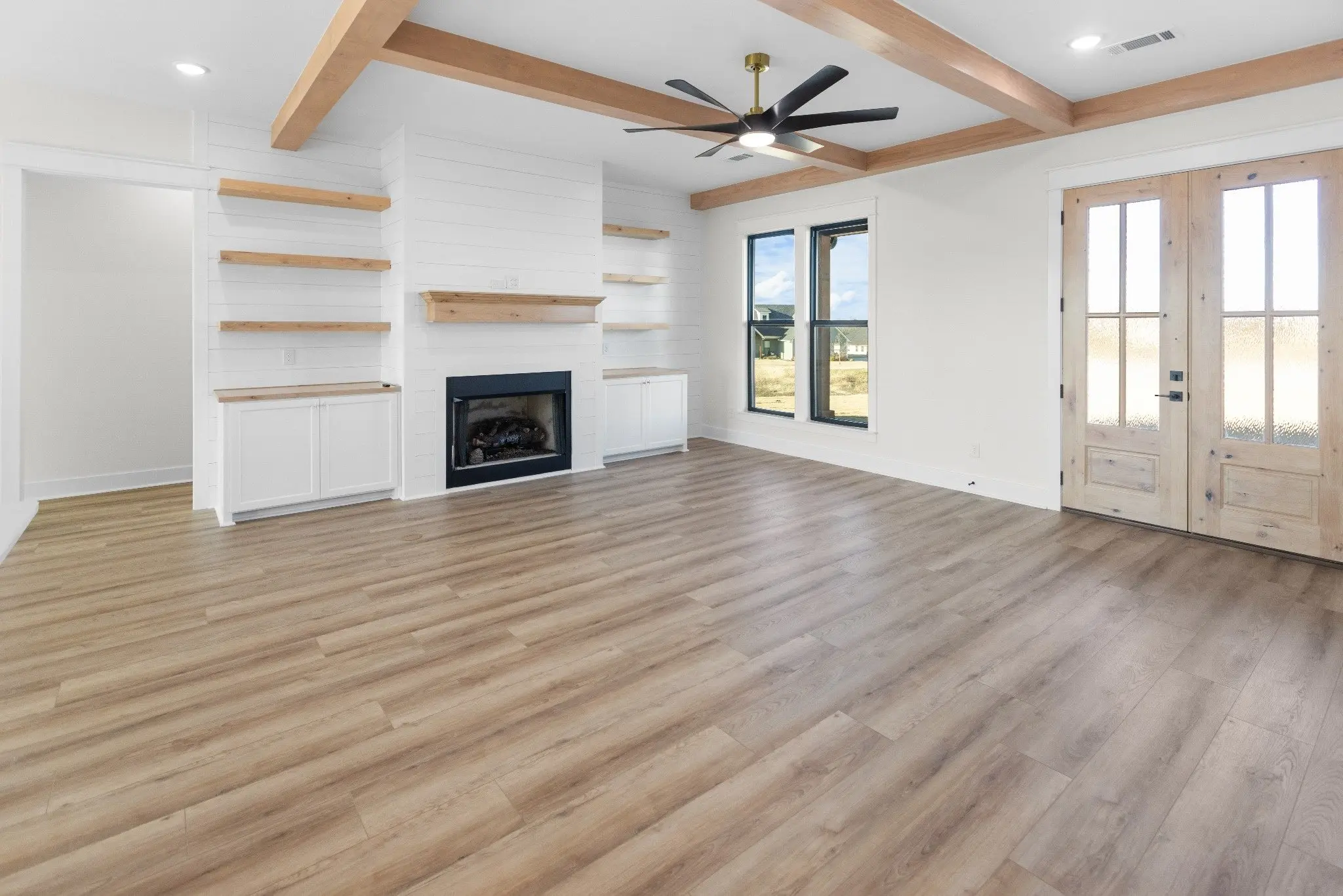 Great room with a fireplace, built-ins and French doors, The Wester House, a custom home in Sherman, Texas