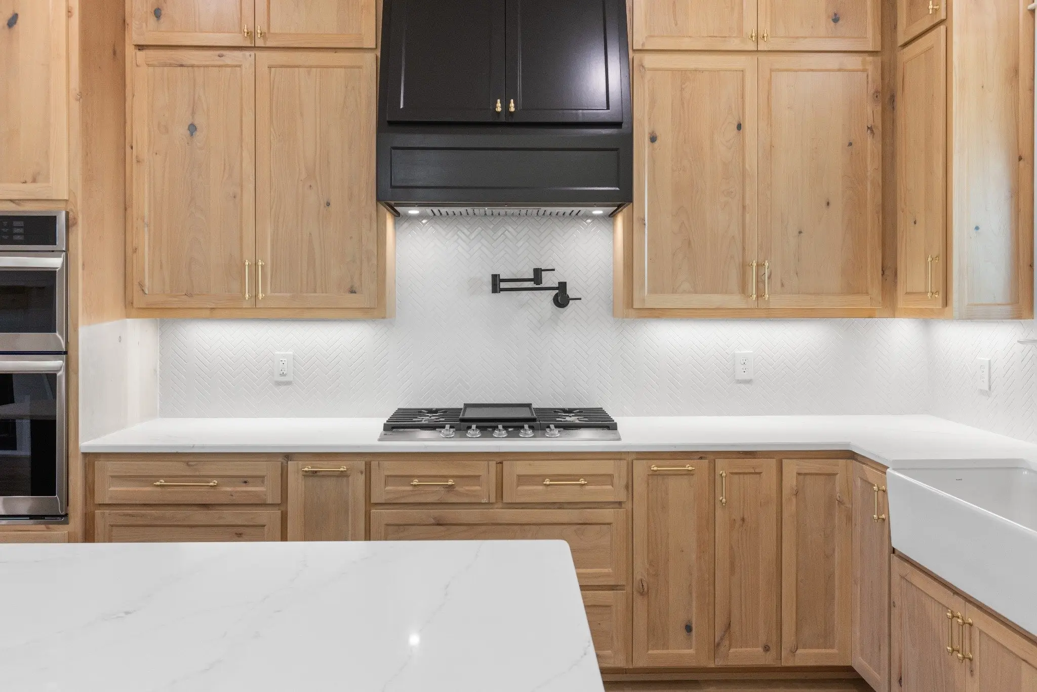 Kitchen with a gas range, vent hood and farmhouse sink, The Wester House, a custom home in Sherman, Texas