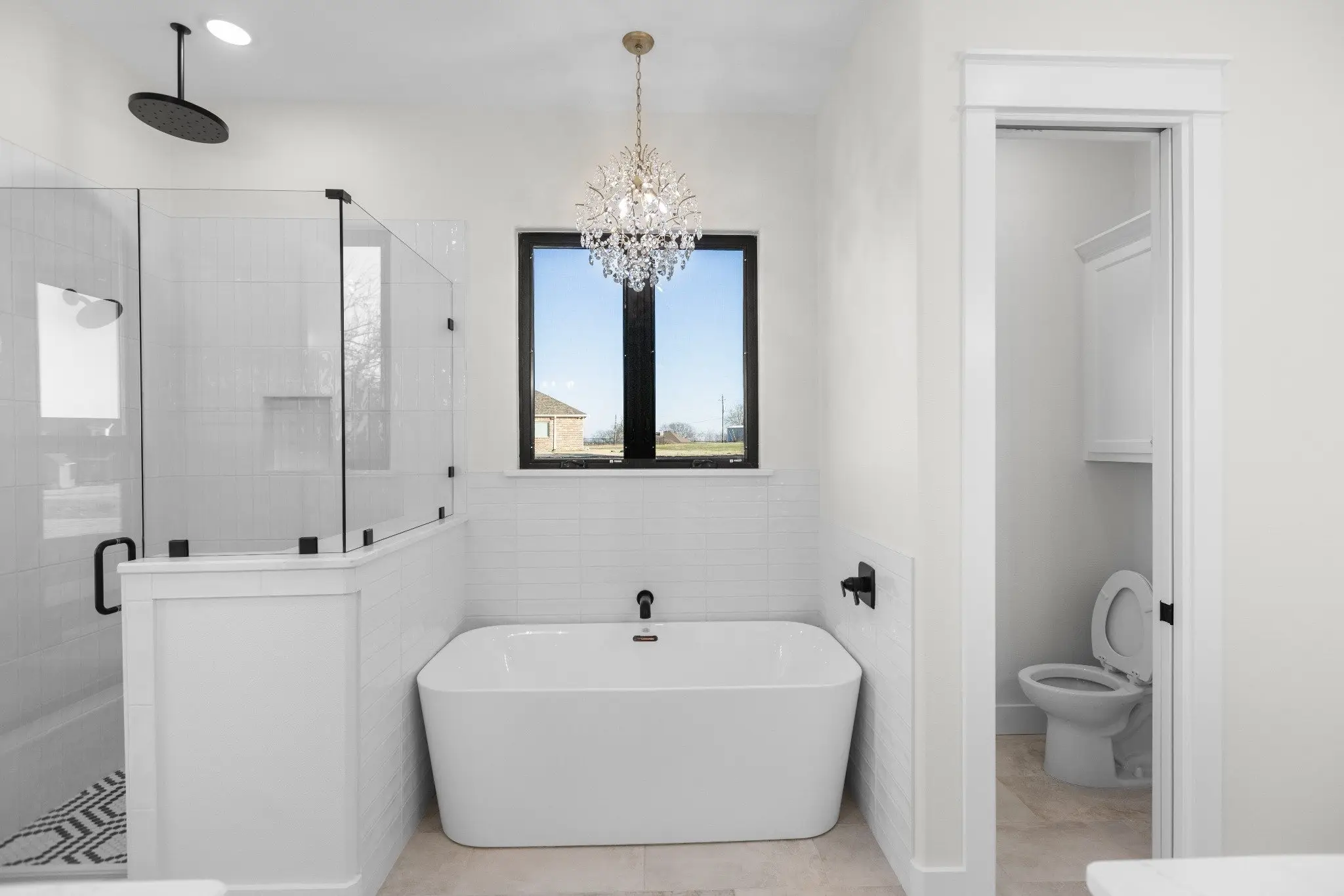 Primary bathroom with a freestanding tub and glass shower, The Wester House, a custom home in Sherman, Texas